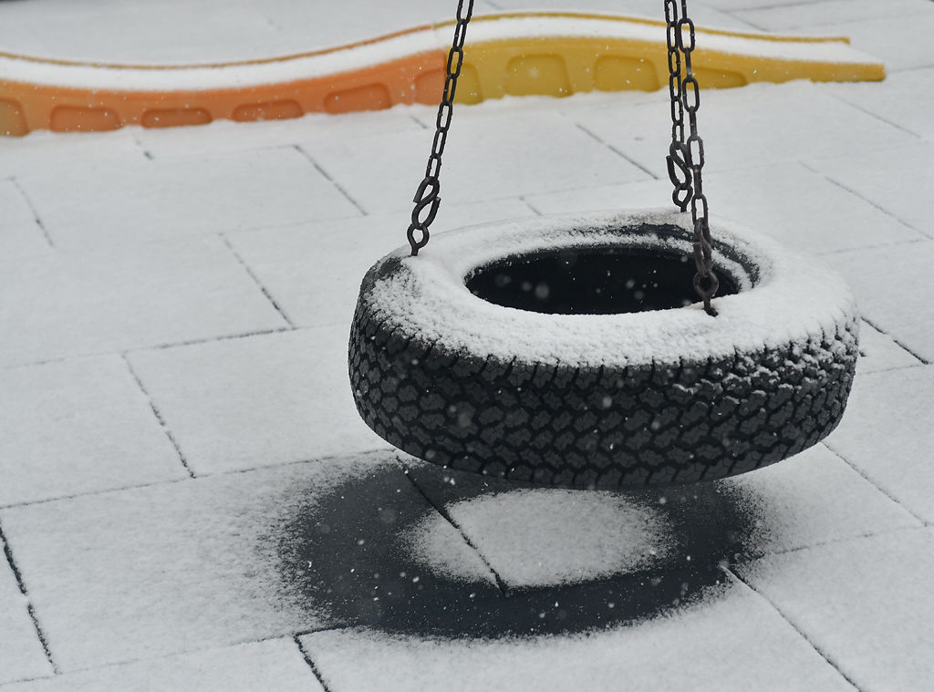 Snow covers a tire swing